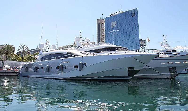 a large white yacht in a harbor aboard KESTREL Yacht for Sale