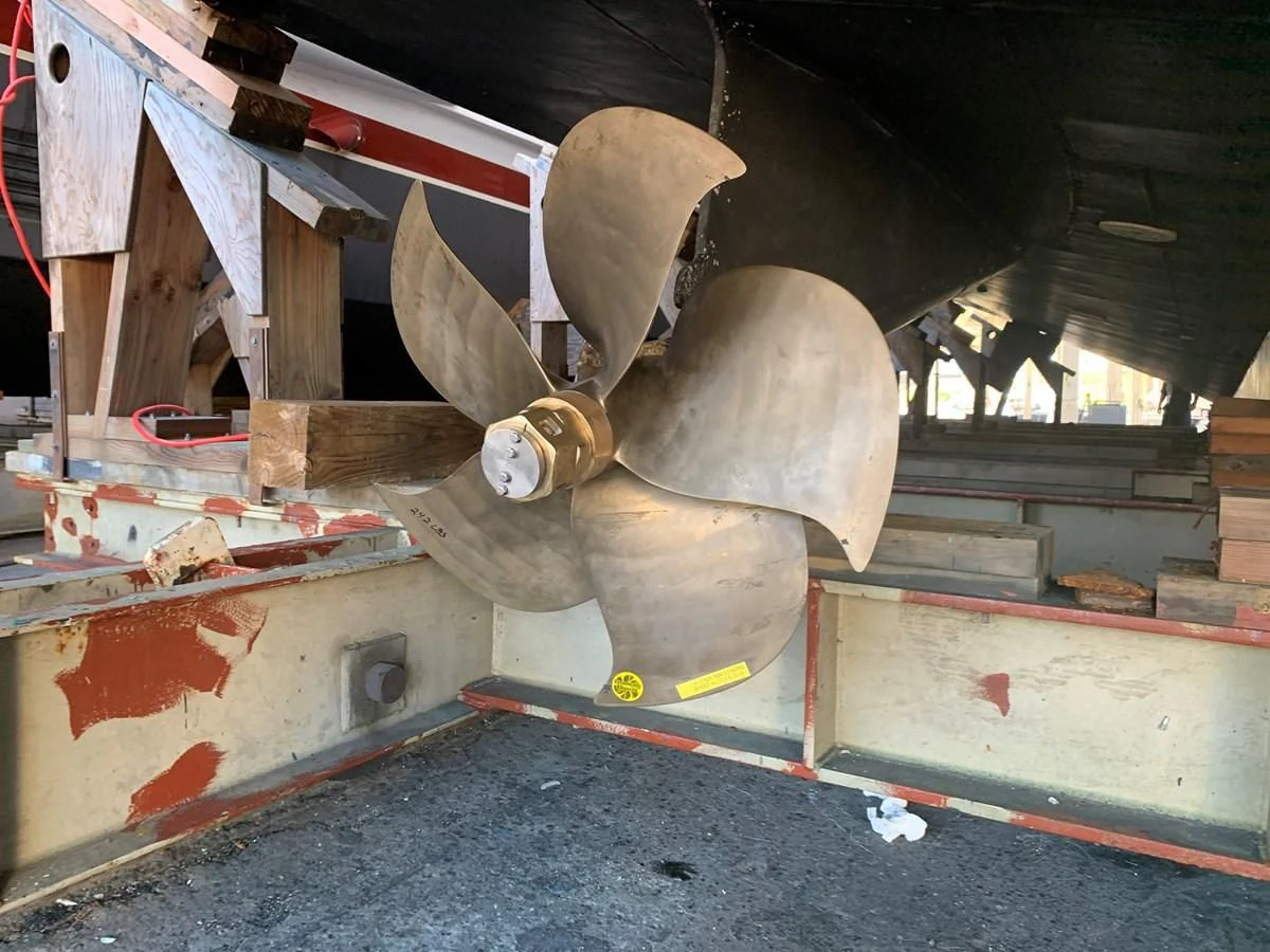 a large piece of wood being held by a machine aboard AVALON Yacht for Sale