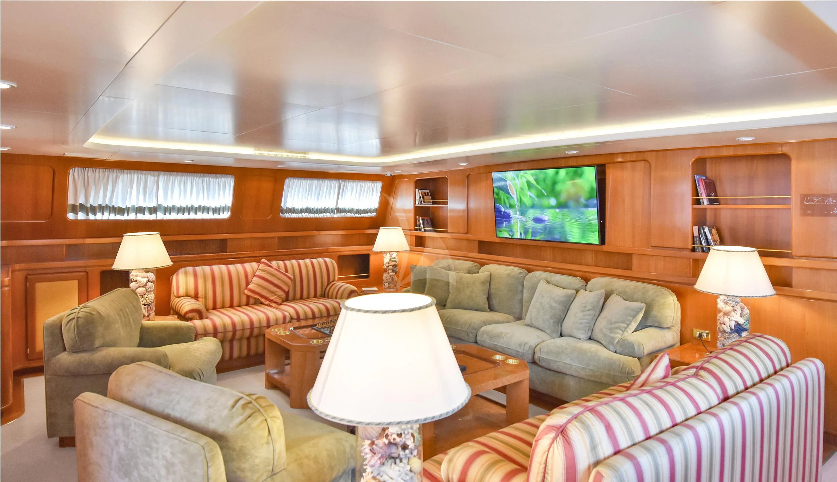 a living room with a large screen aboard TAMARITA Yacht for Sale