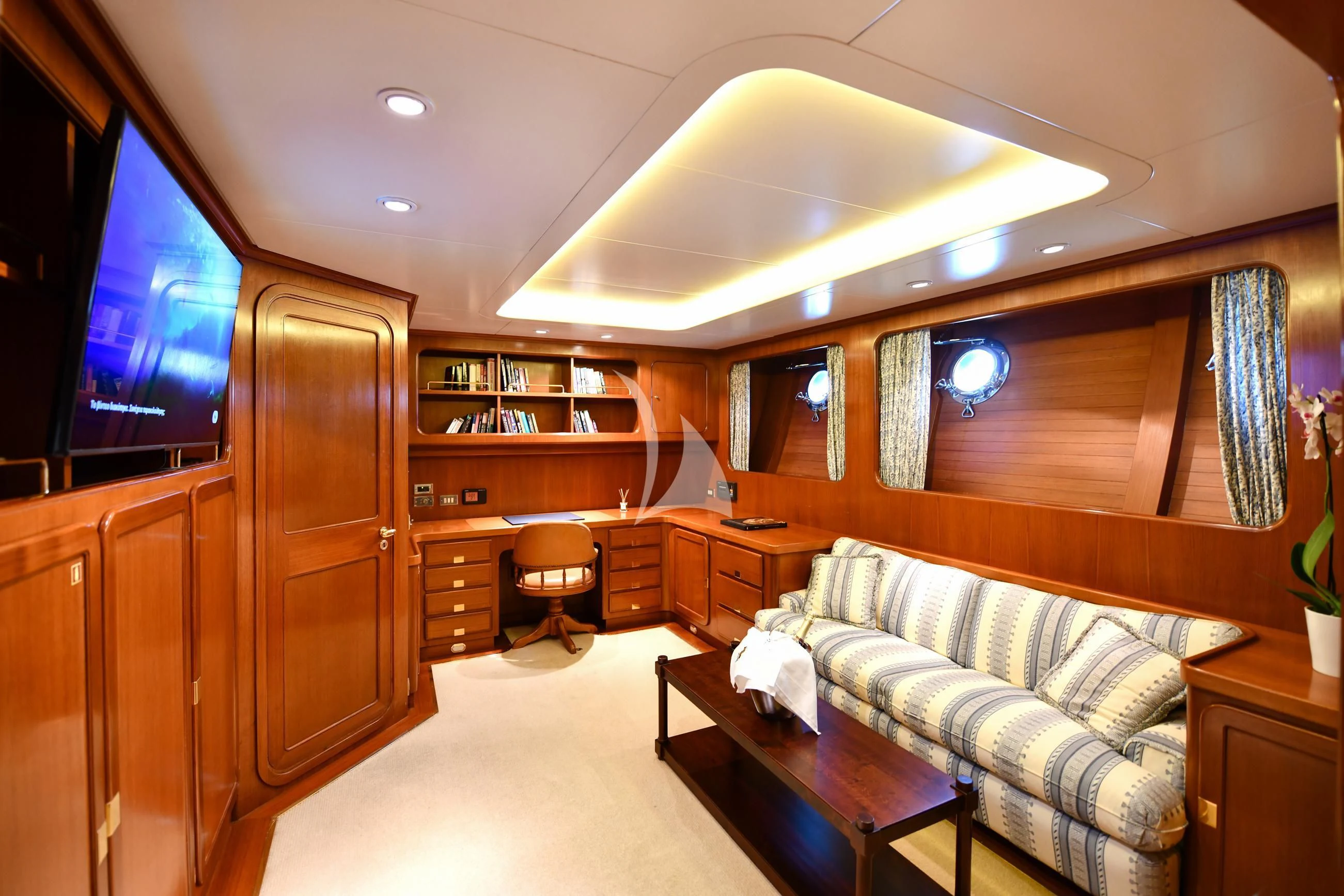a living room with a couch and a tv aboard TAMARITA Yacht for Sale