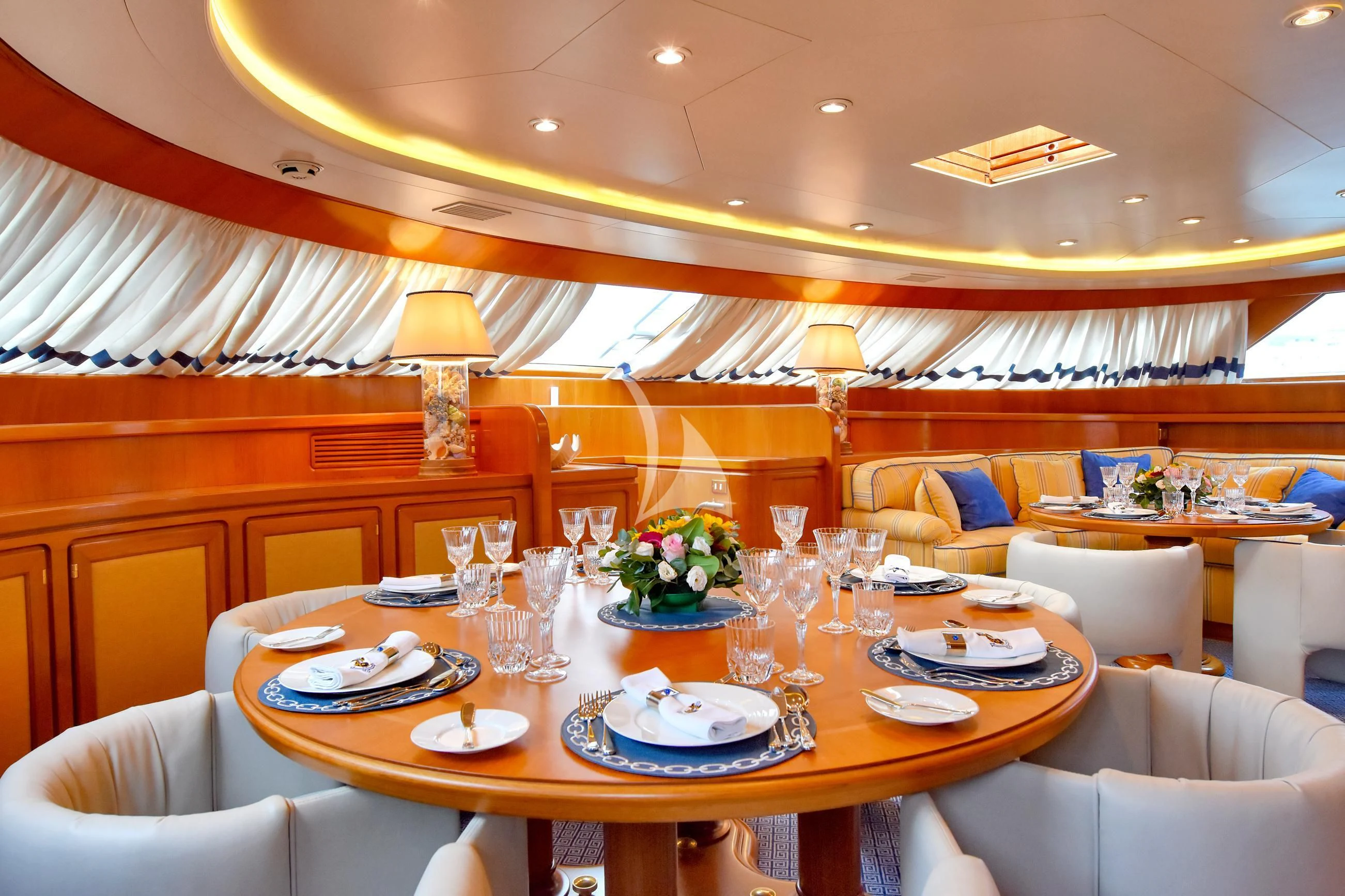 a dining room with a table set for a dinner aboard TAMARITA Yacht for Sale