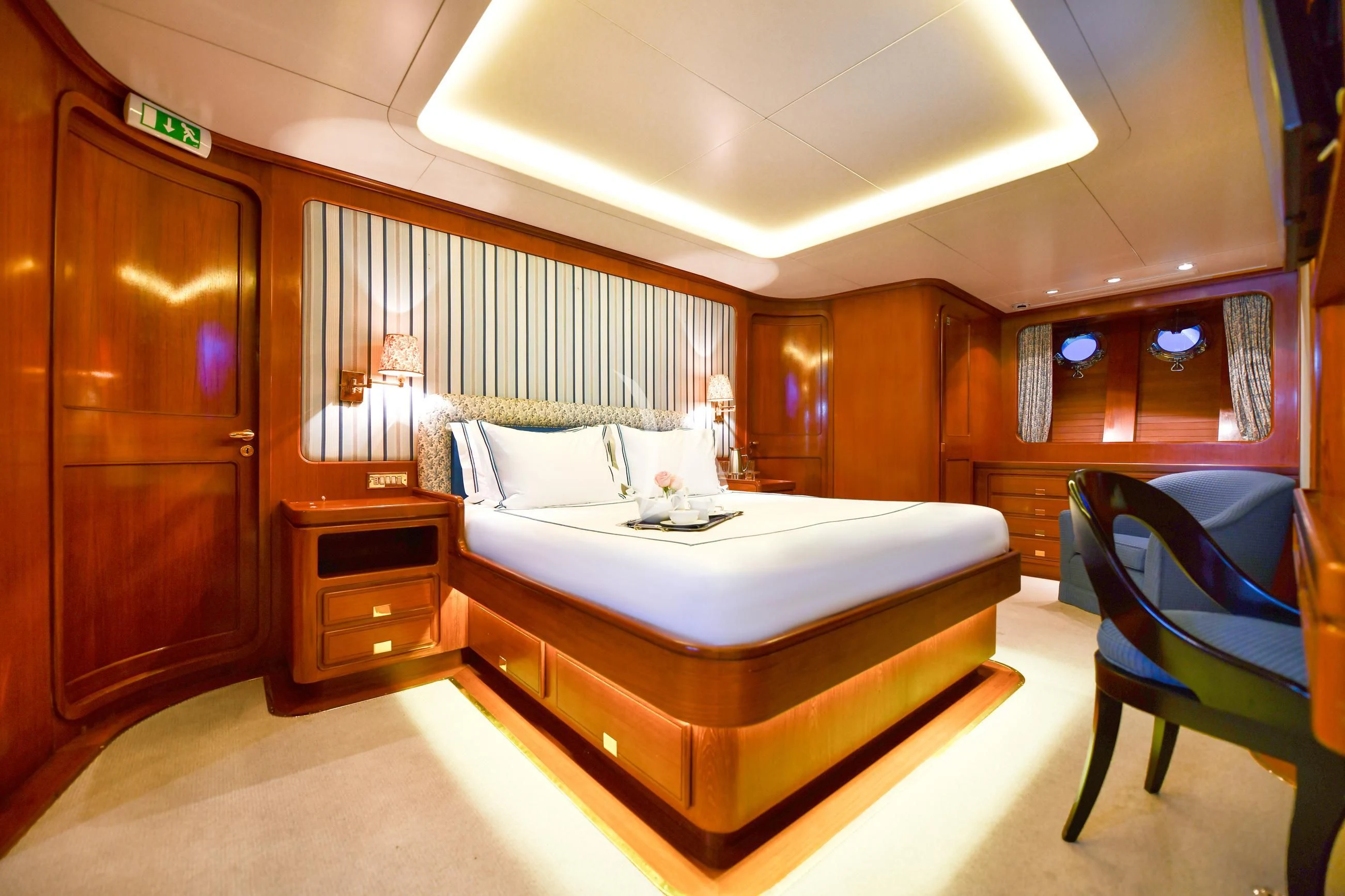 a room with a bed and a chair aboard TAMARITA Yacht for Sale