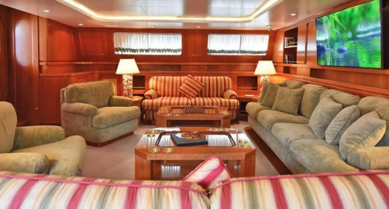 a living room with couches and a coffee table aboard TAMARITA Yacht for Sale