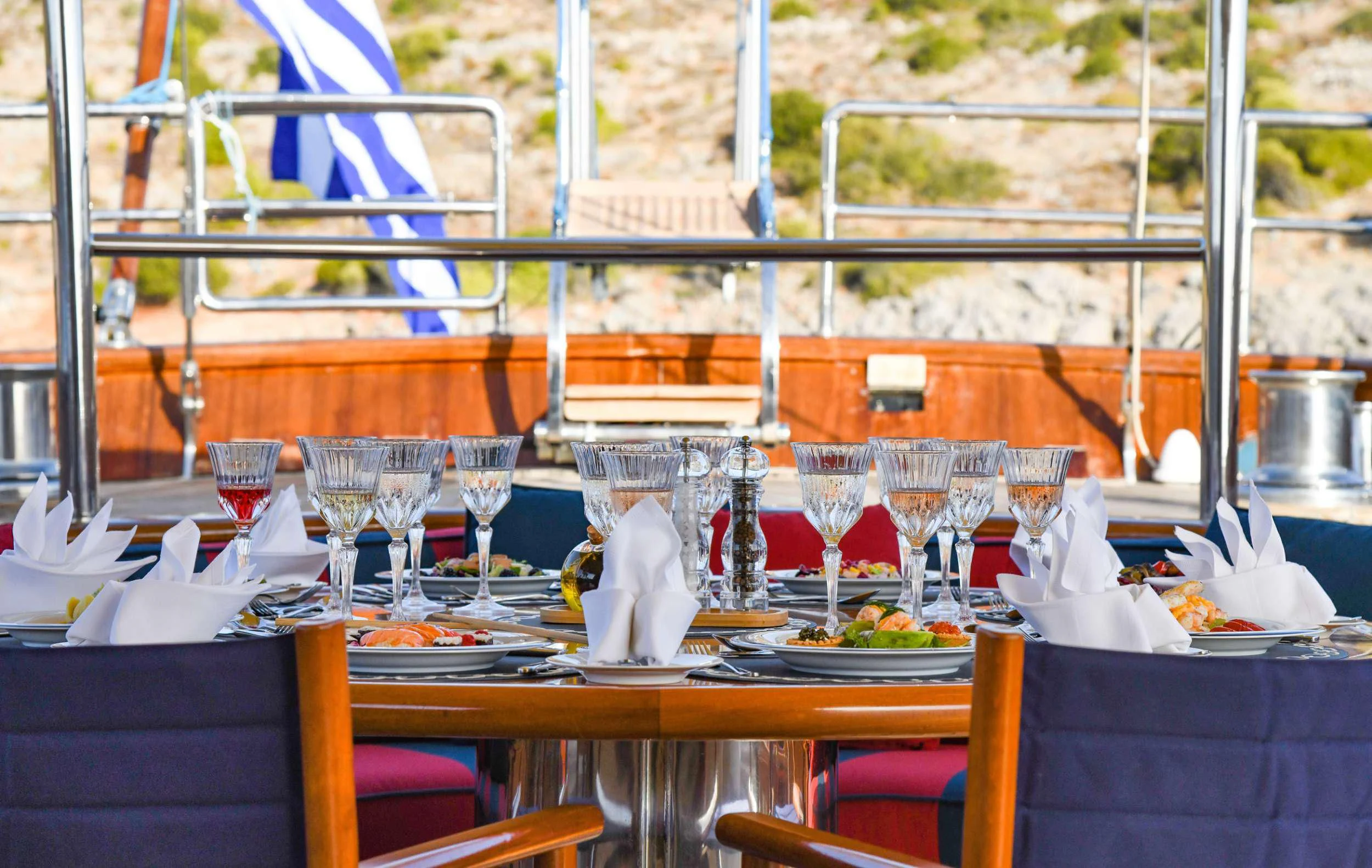 a table set with food and wine glasses aboard TAMARITA Yacht for Sale