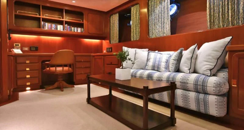 a living room with a couch and a coffee table aboard TAMARITA Yacht for Sale