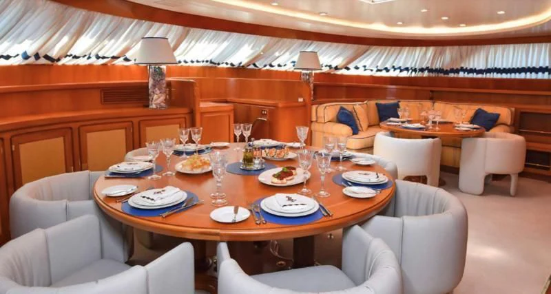 a large dining table in a room aboard TAMARITA Yacht for Sale