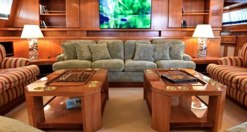 a living room with a couch and coffee table aboard TAMARITA Yacht for Sale