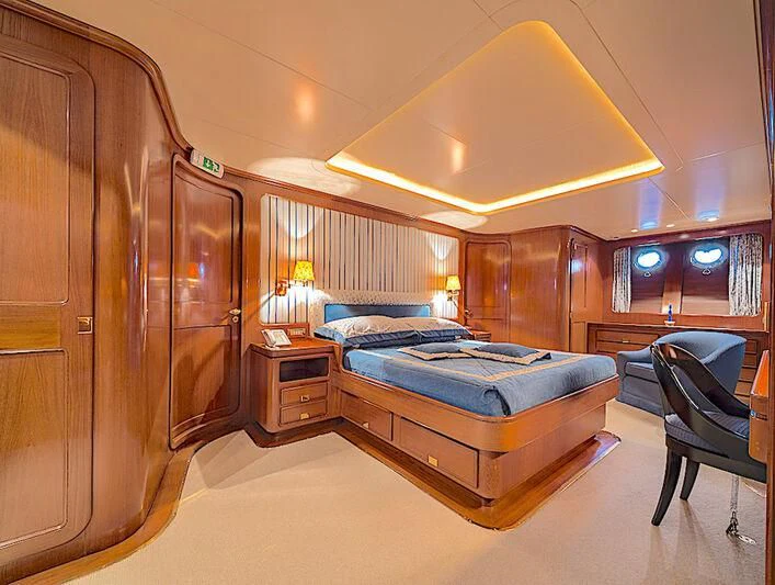 a bedroom with a bed and a desk aboard TAMARITA Yacht for Sale