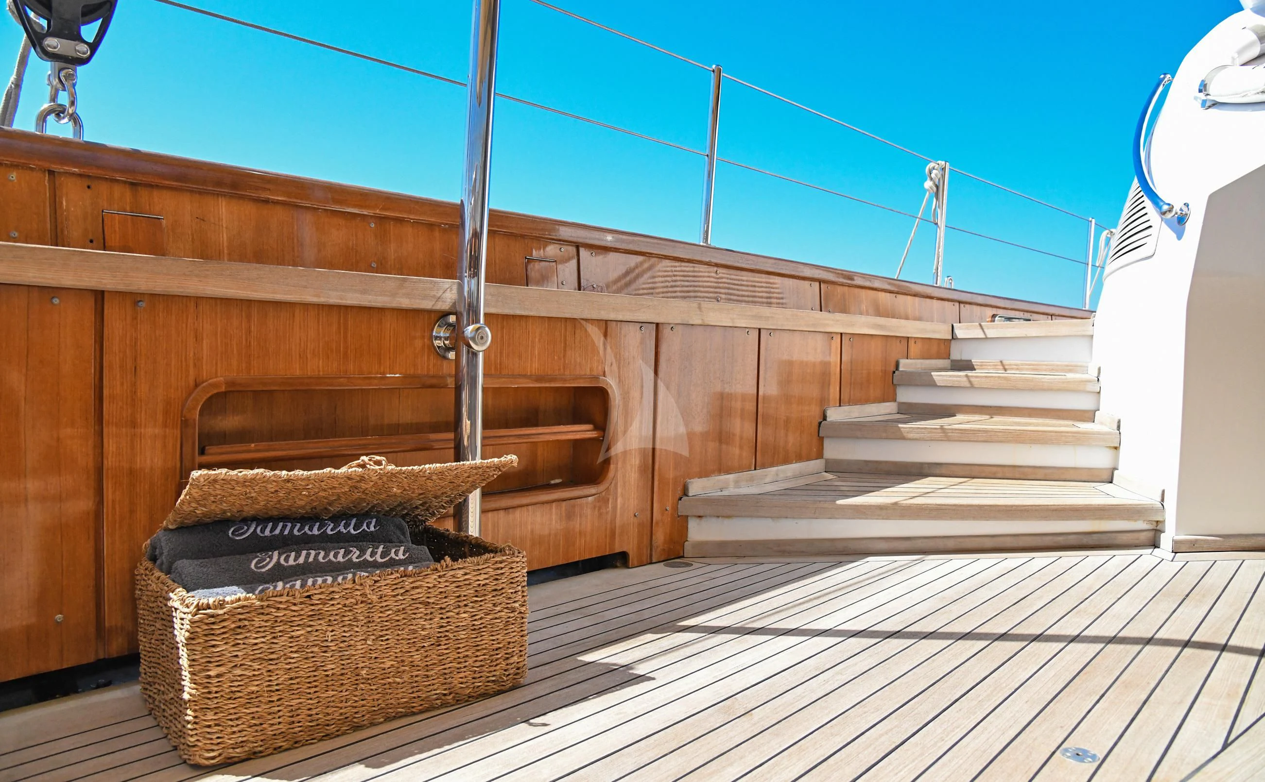 a wood deck with a basket and a basket on it aboard TAMARITA Yacht for Sale
