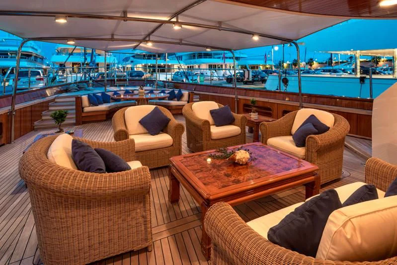 a room with couches and a table and chairs aboard TAMARITA Yacht for Sale