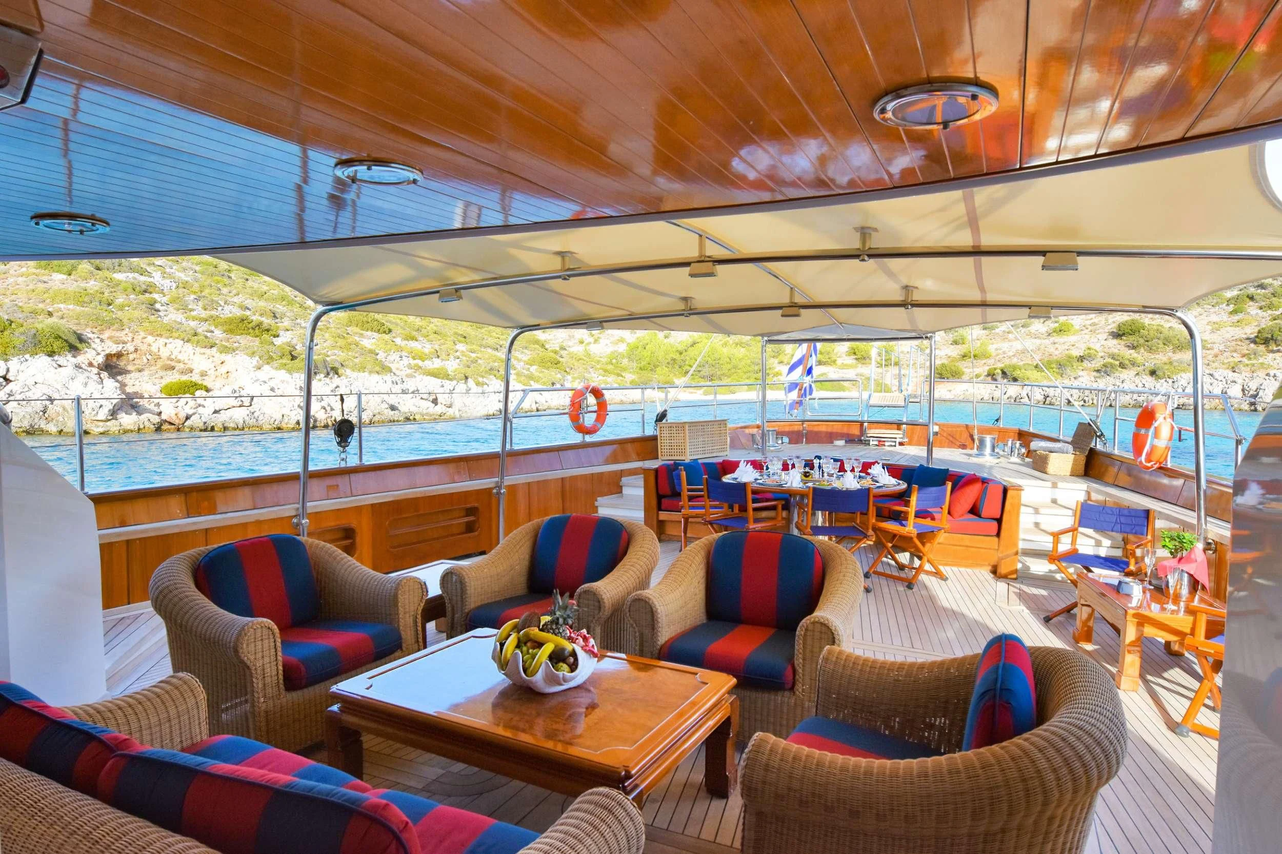 a boat with a table and chairs aboard TAMARITA Yacht for Sale