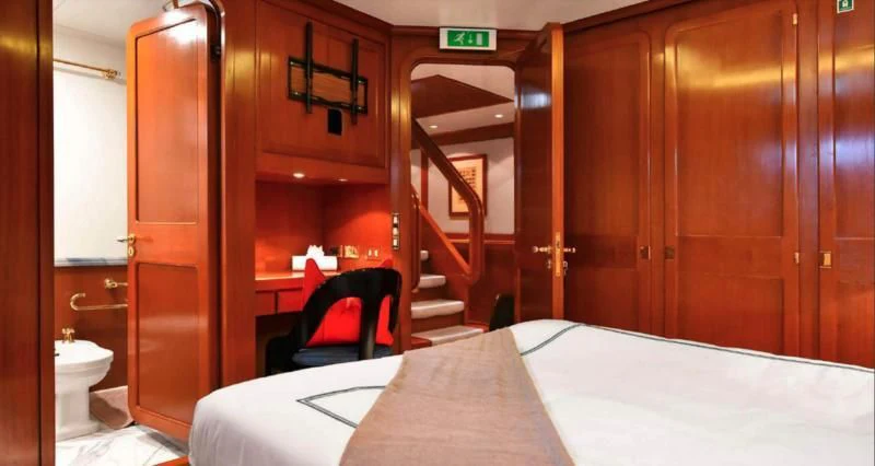 a room with a bed and a chair aboard TAMARITA Yacht for Sale