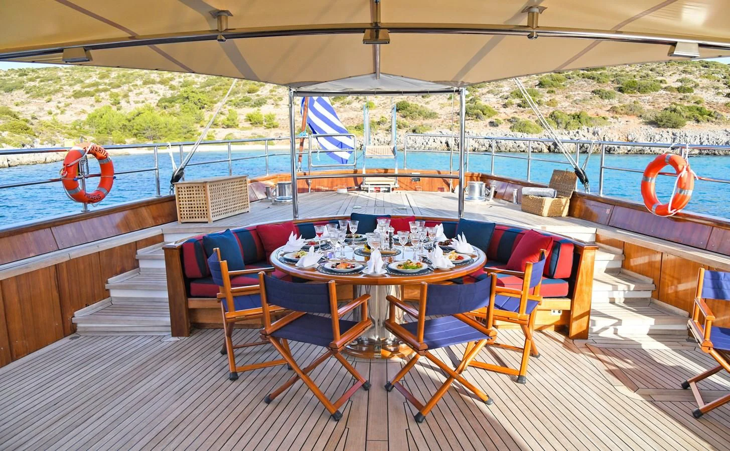 a deck with a table and chairs aboard TAMARITA Yacht for Sale