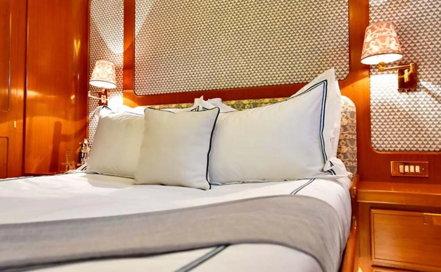 a bed with white sheets and pillows aboard TAMARITA Yacht for Sale