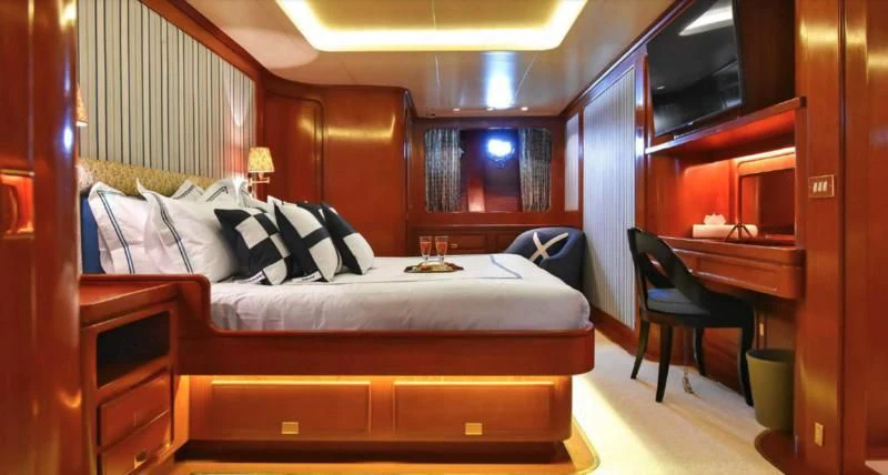a room with a bed and a desk aboard TAMARITA Yacht for Sale