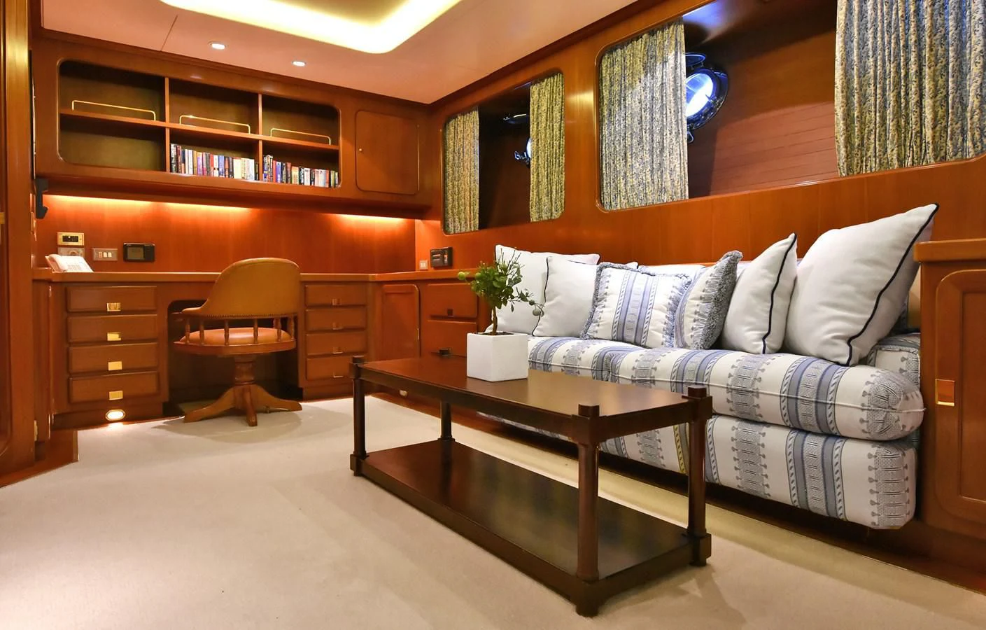a living room with a couch and coffee table aboard TAMARITA Yacht for Sale