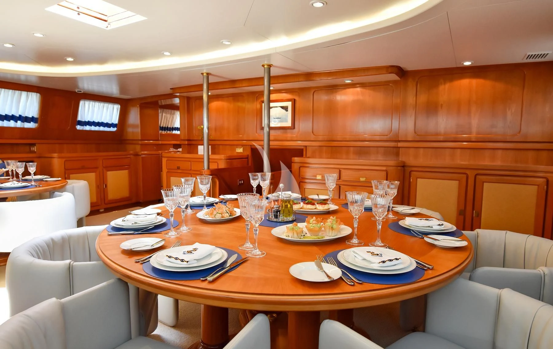 a table with plates and glasses on it aboard TAMARITA Yacht for Sale