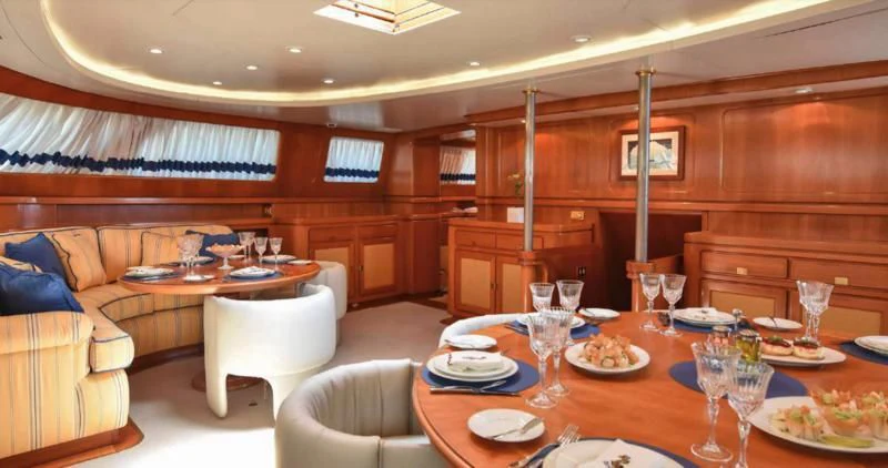 a dining table in a living room aboard TAMARITA Yacht for Sale