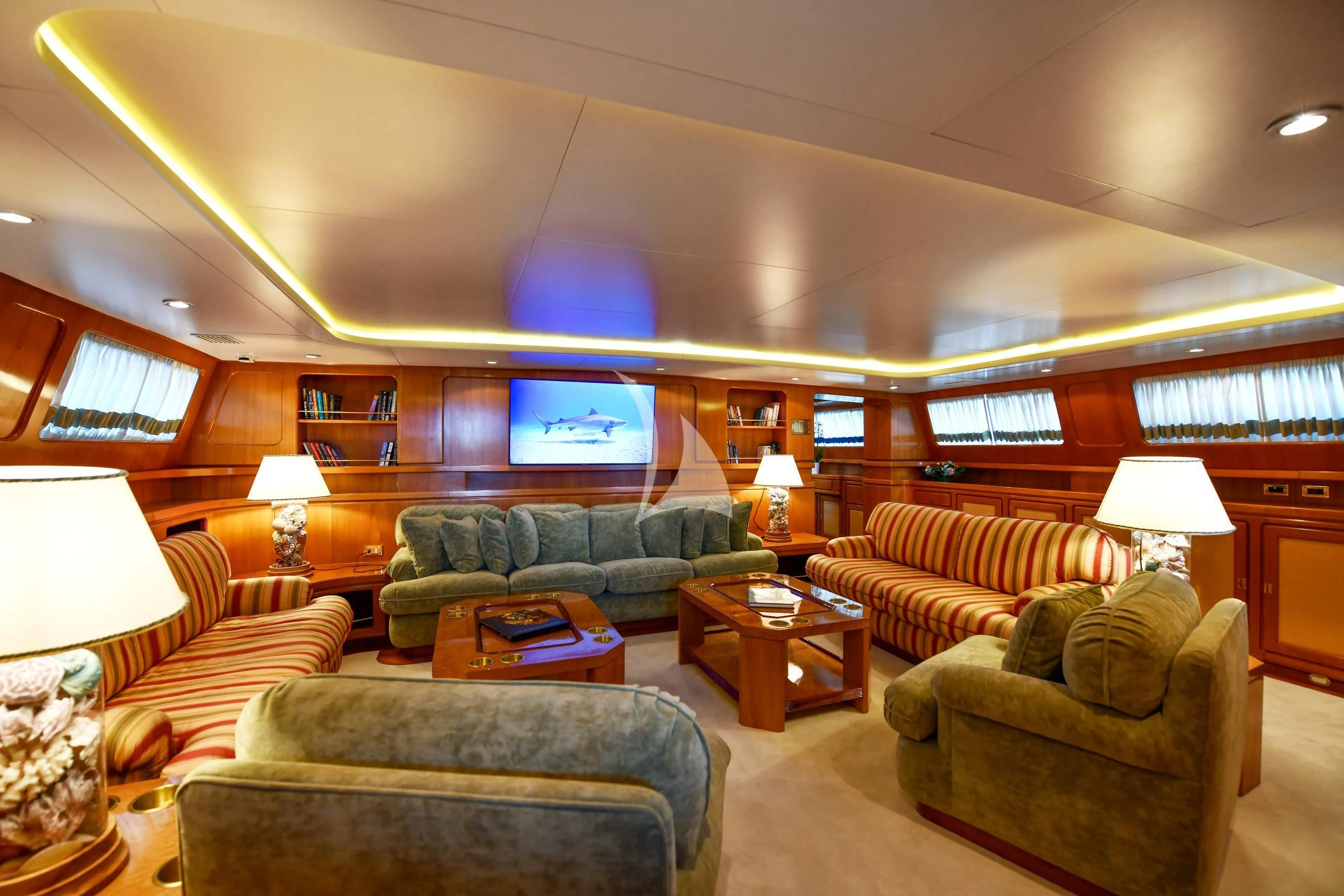 a living room with couches and a television aboard TAMARITA Yacht for Sale