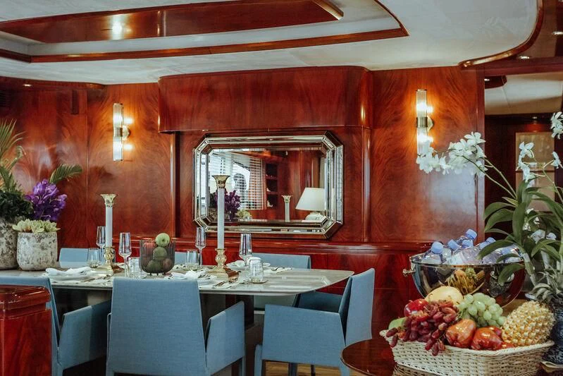 a dining table with a basket of fruits and a basket of grapes aboard FOR YOUR EYES ONLY Yacht for Charter