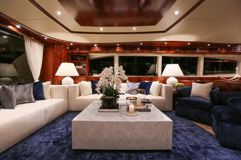 a living room with a blue couch and white furniture aboard FOR YOUR EYES ONLY Yacht for Charter