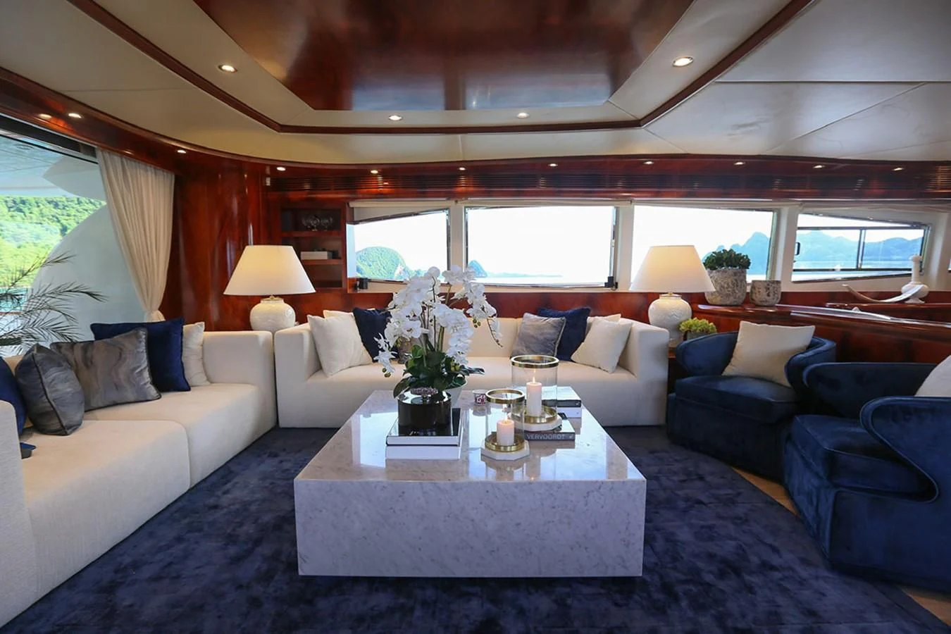 a living room with a large blue couch and a white coffee table aboard FOR YOUR EYES ONLY Yacht for Charter