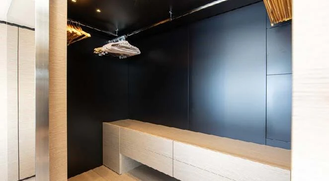 a room with a black wall and a white box with a black door aboard HAIAMI I Yacht for Charter