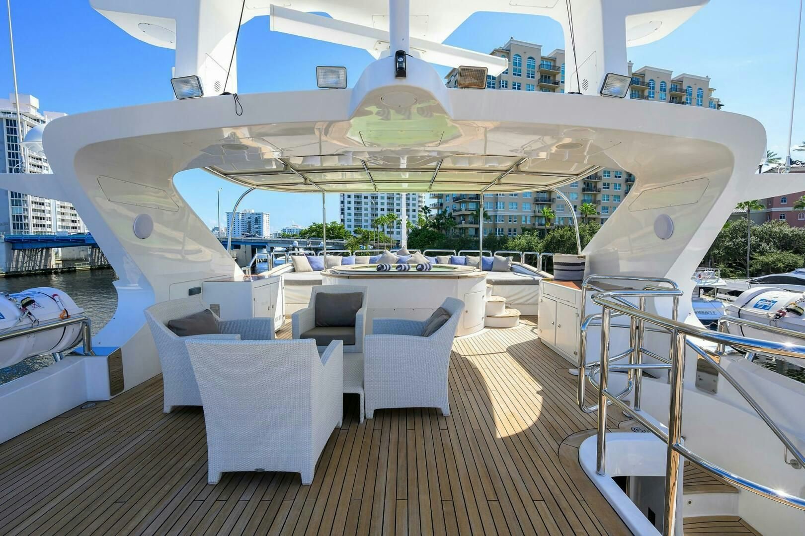 a large white lounge chair on a deck overlooking a large building aboard ARTHUR’S WAY Yacht for Sale