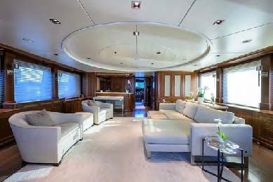 a large living room with a large chandelier aboard ARTHUR’S WAY Yacht for Sale