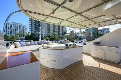 a room with a large white table and chairs and a large building with glass windows aboard ARTHUR’S WAY Yacht for Sale