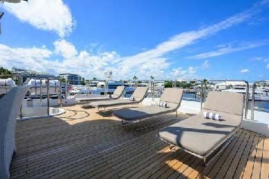 a deck with lounge chairs on it aboard ARTHUR’S WAY Yacht for Sale