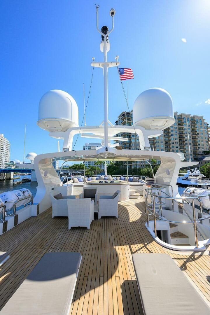 a deck with a large ship in the background aboard ARTHUR’S WAY Yacht for Sale