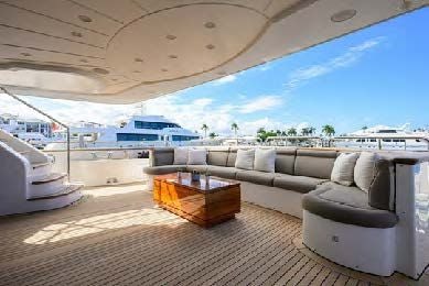 a large living room with a large patio and a large ship in the background aboard ARTHUR’S WAY Yacht for Sale