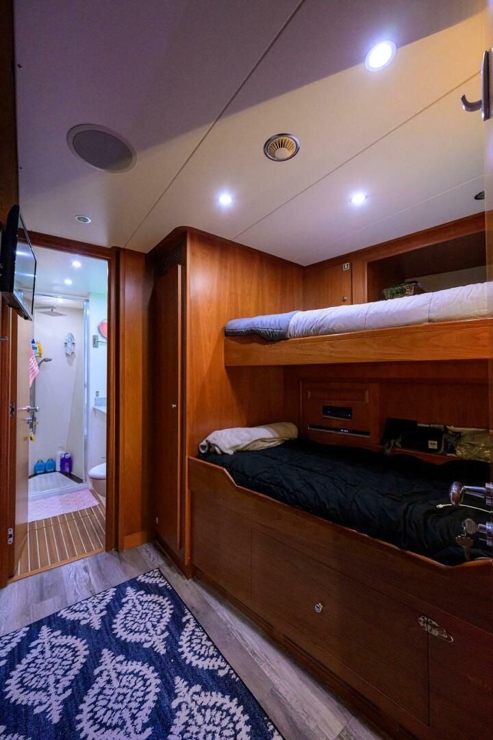 a bedroom with a bed and a mirror aboard ARTHUR’S WAY Yacht for Sale