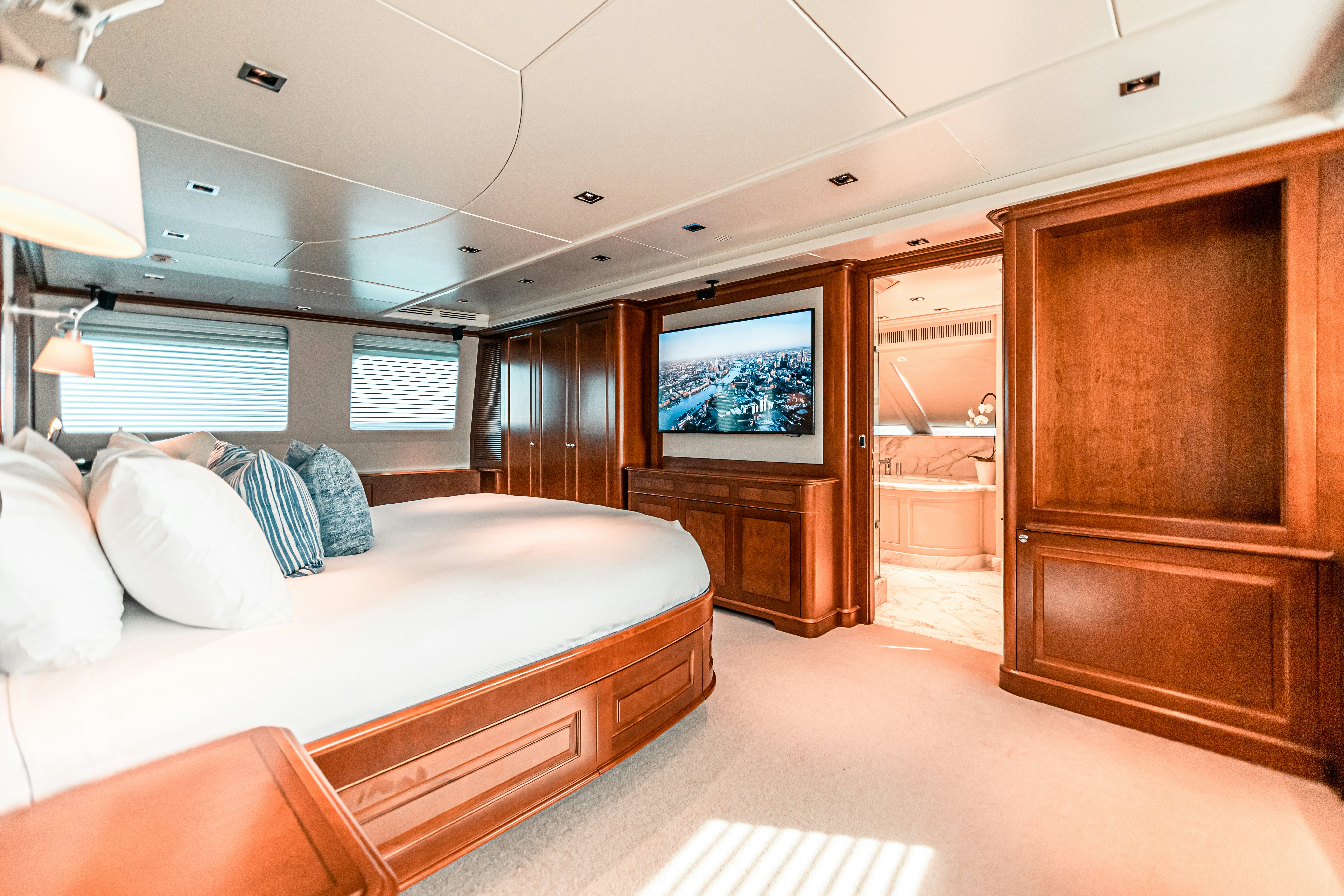 a bedroom with a bed and a wood cabinet aboard ARTHUR’S WAY Yacht for Sale