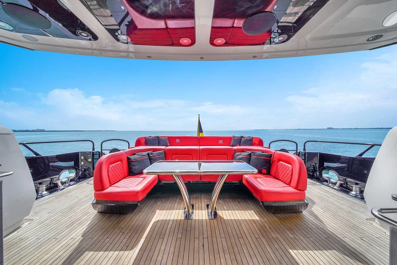 a red and white boat on a deck with a table and chairs aboard SUNSEEKER 115 SPORT YACHT Yacht for Sale