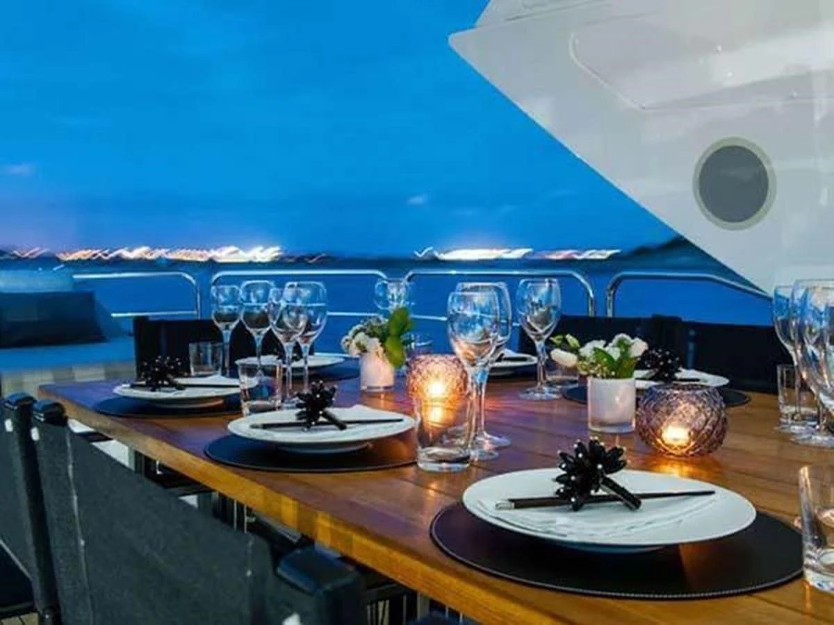 a table with wine glasses and plates aboard SUNSEEKER 115 SPORT YACHT Yacht for Sale