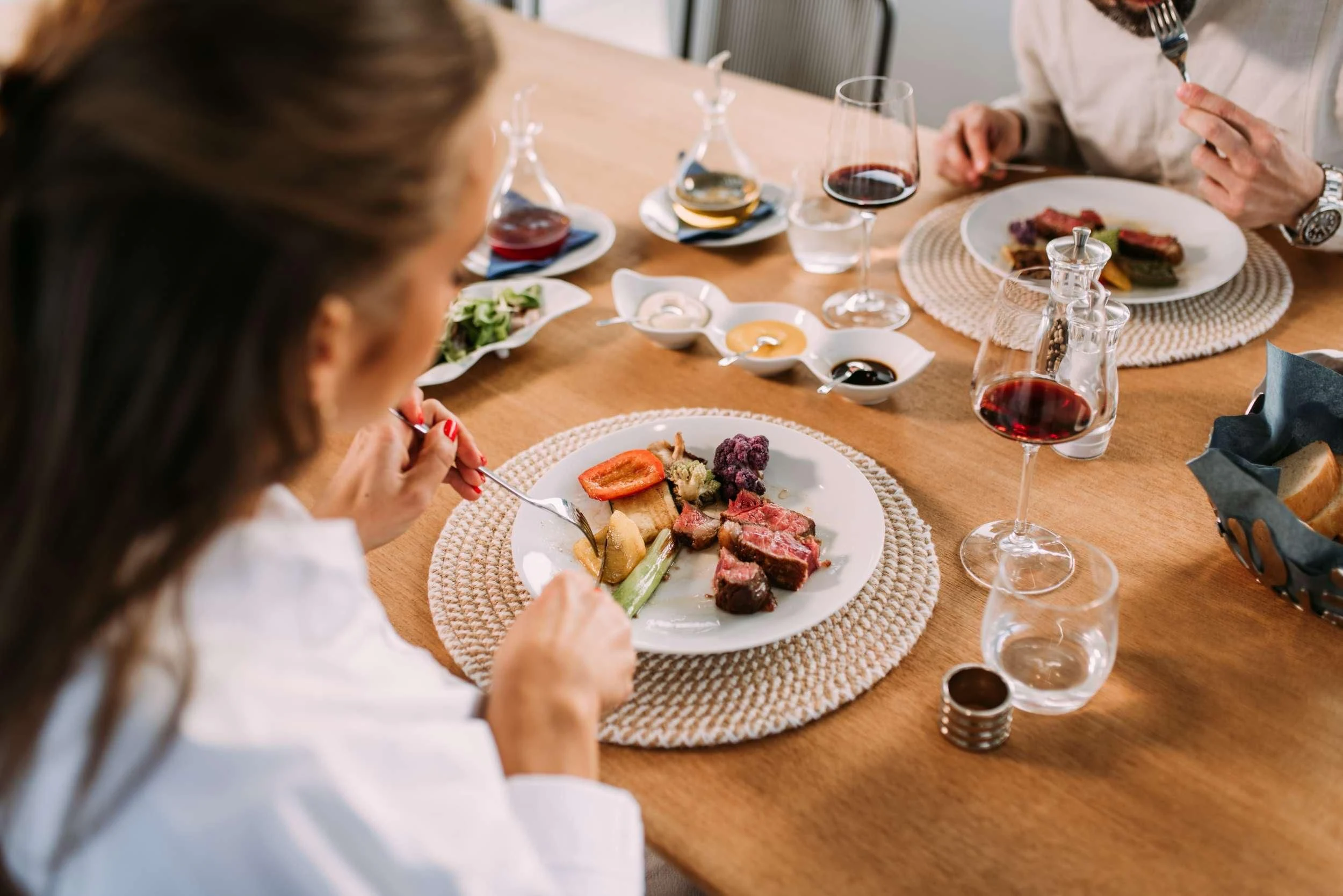 a woman eating a meal at a restaurant aboard PARALOS Yacht for Charter