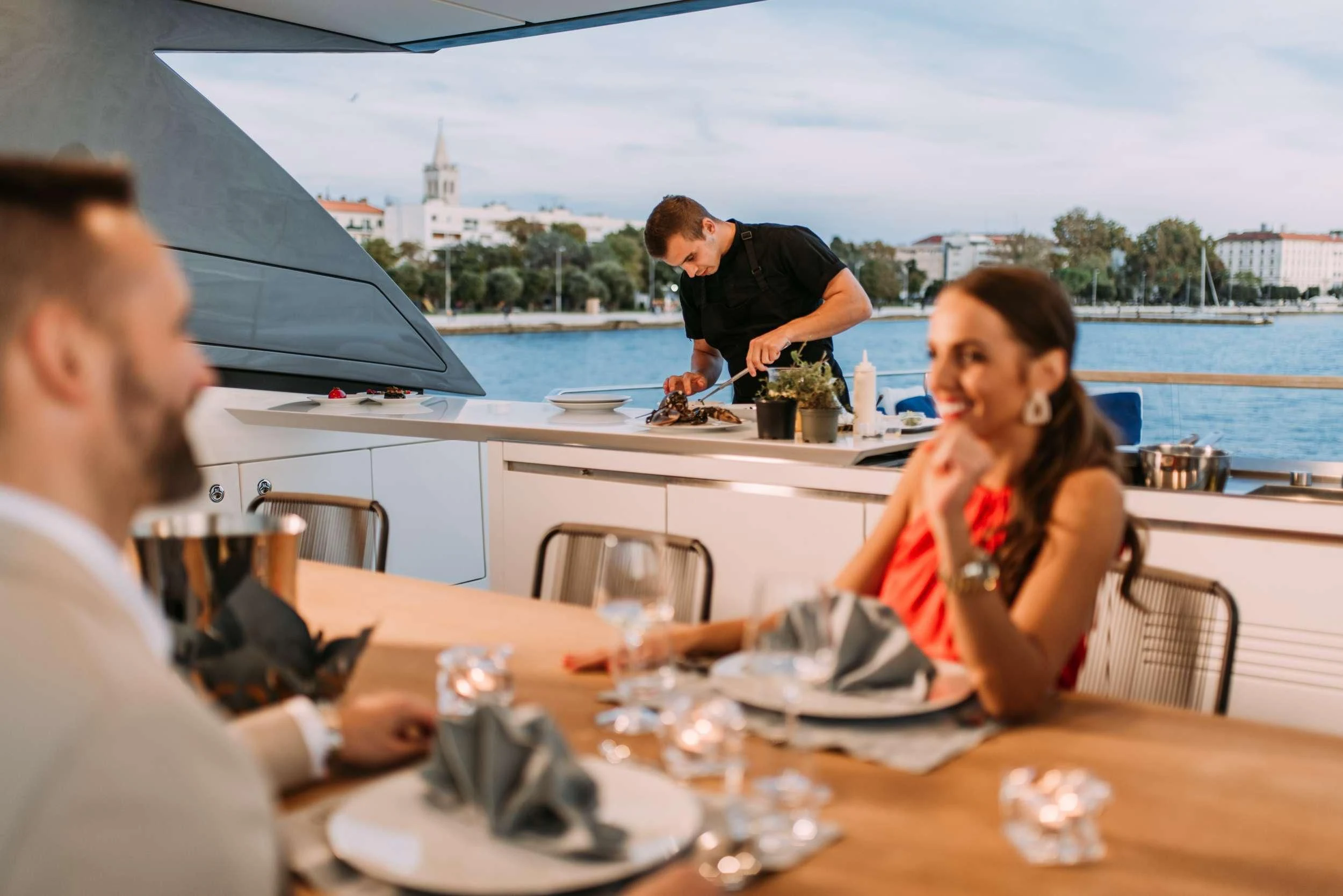 a group of people sitting at a table outside aboard PARALOS Yacht for Charter