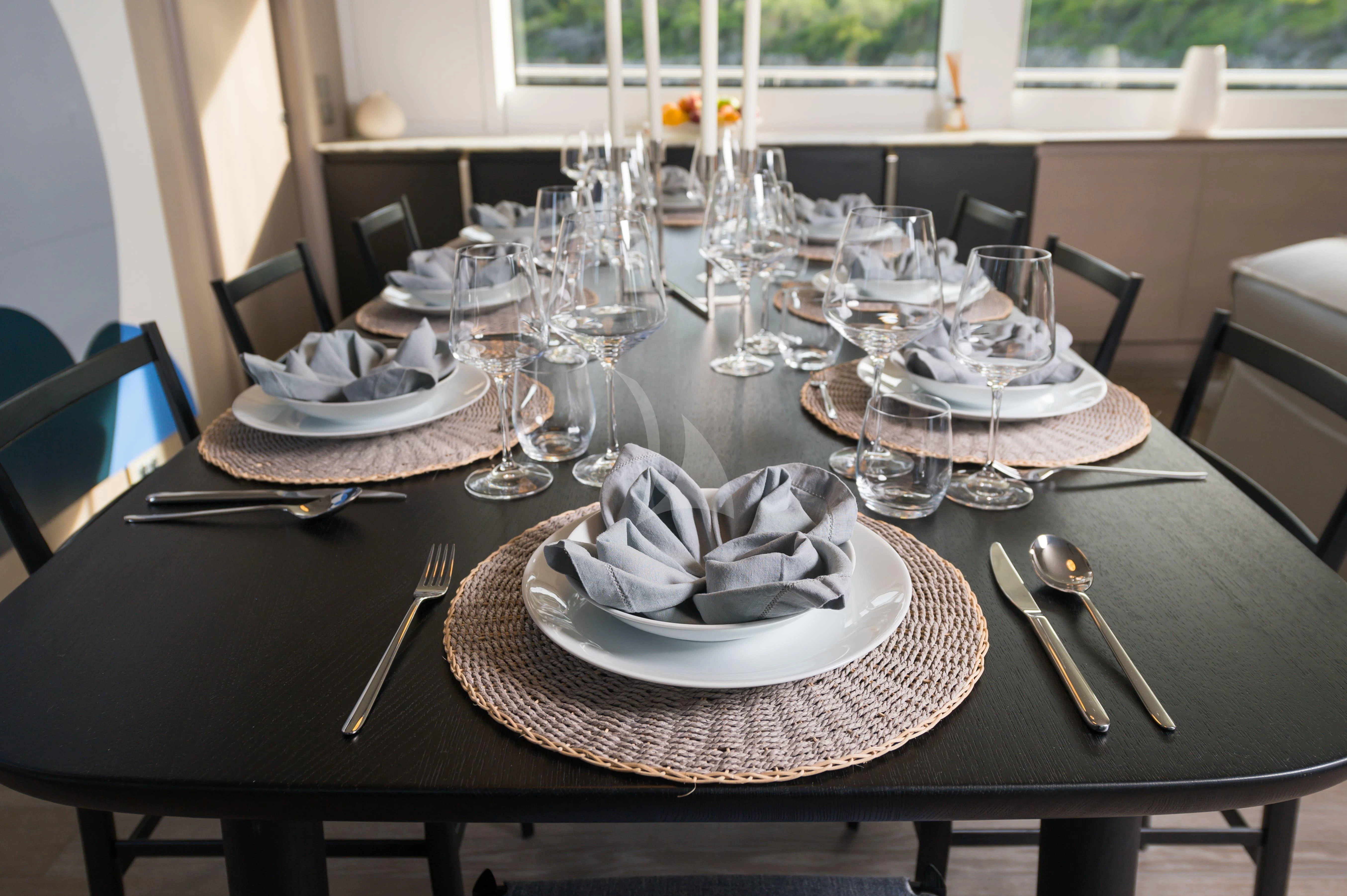 a table with plates and glasses aboard PARALOS Yacht for Charter
