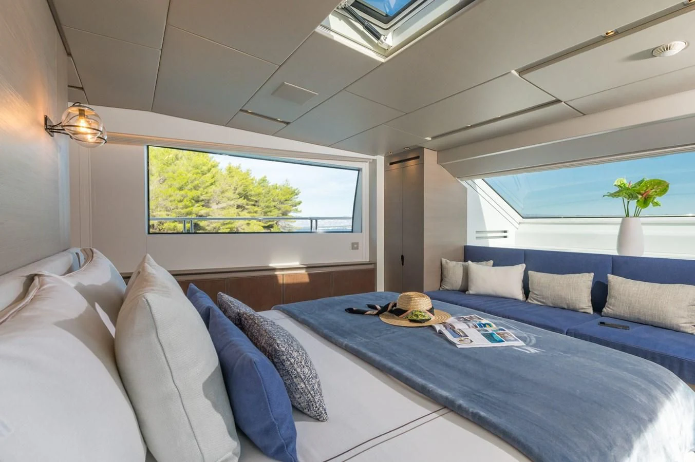 a bed with a blue bed spread aboard PARALOS Yacht for Charter