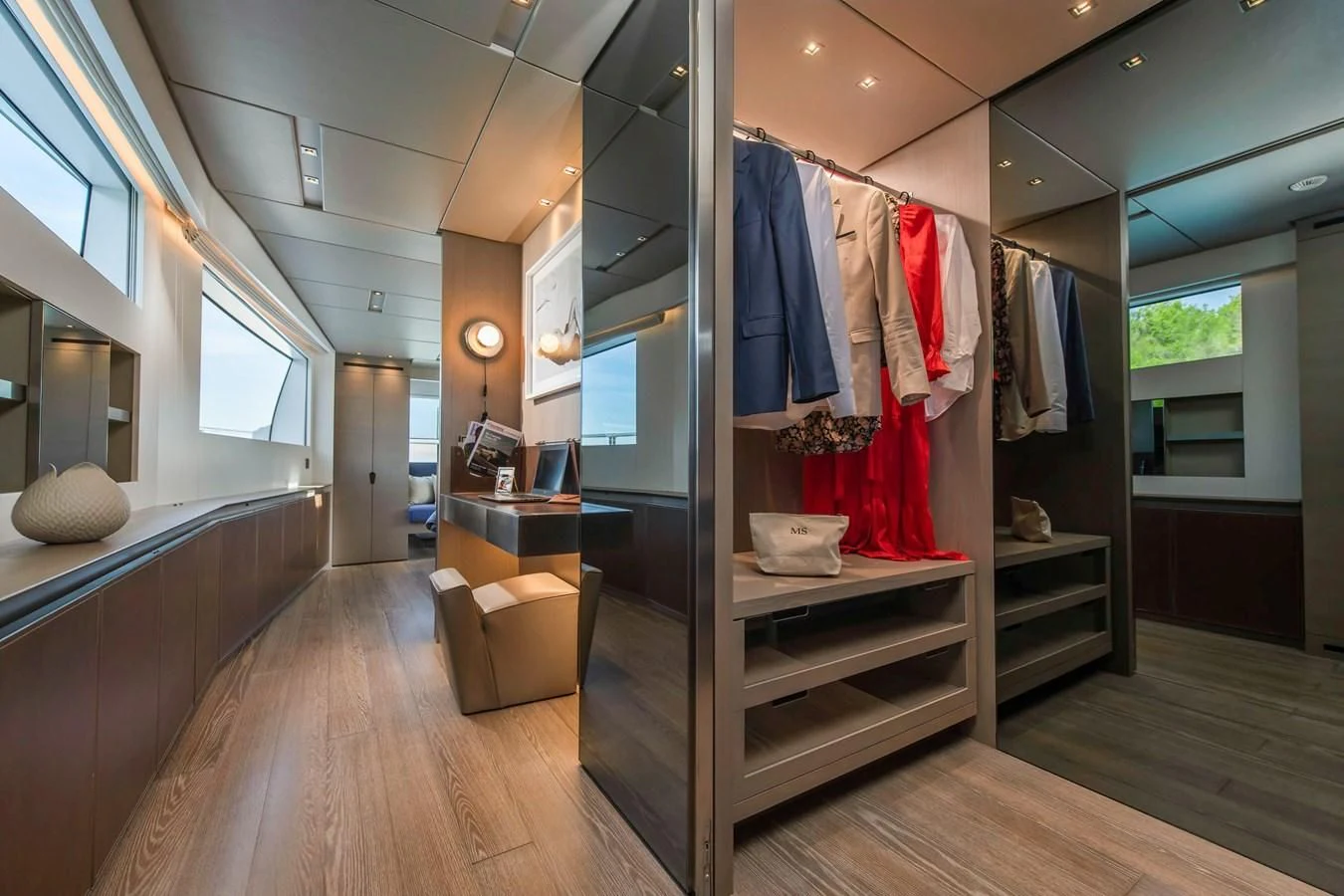 a room with a wood floor and a closet with clothes on the wall aboard PARALOS Yacht for Charter