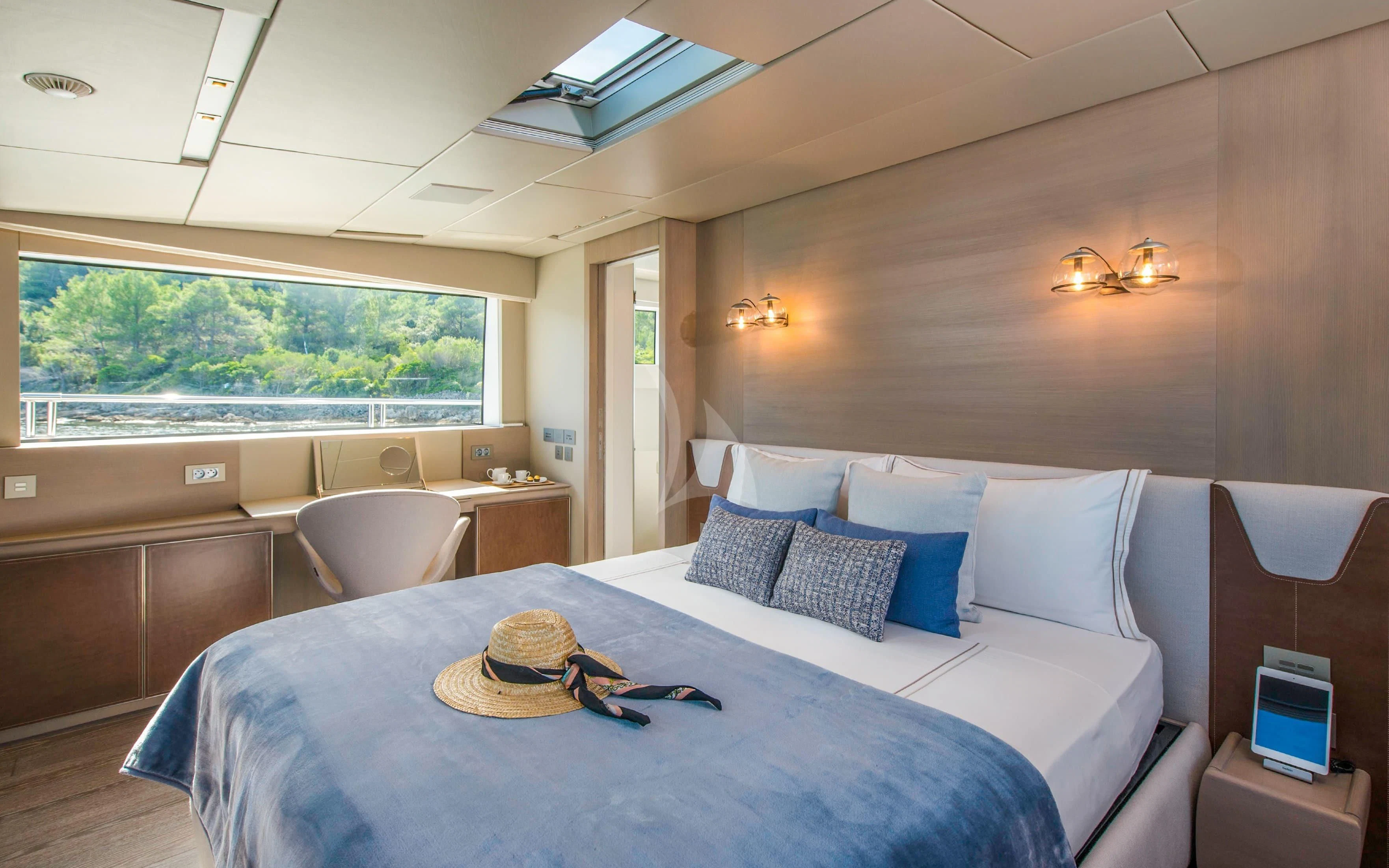 a large bed with a blue and white bed spread aboard PARALOS Yacht for Charter
