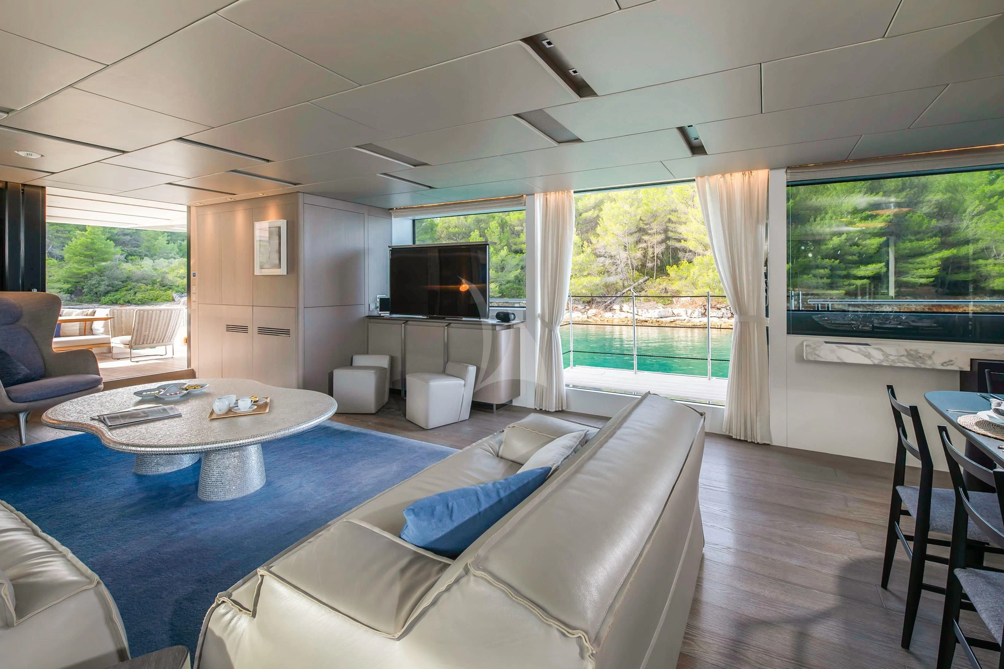 a living room with a large blue table and chairs aboard PARALOS Yacht for Charter