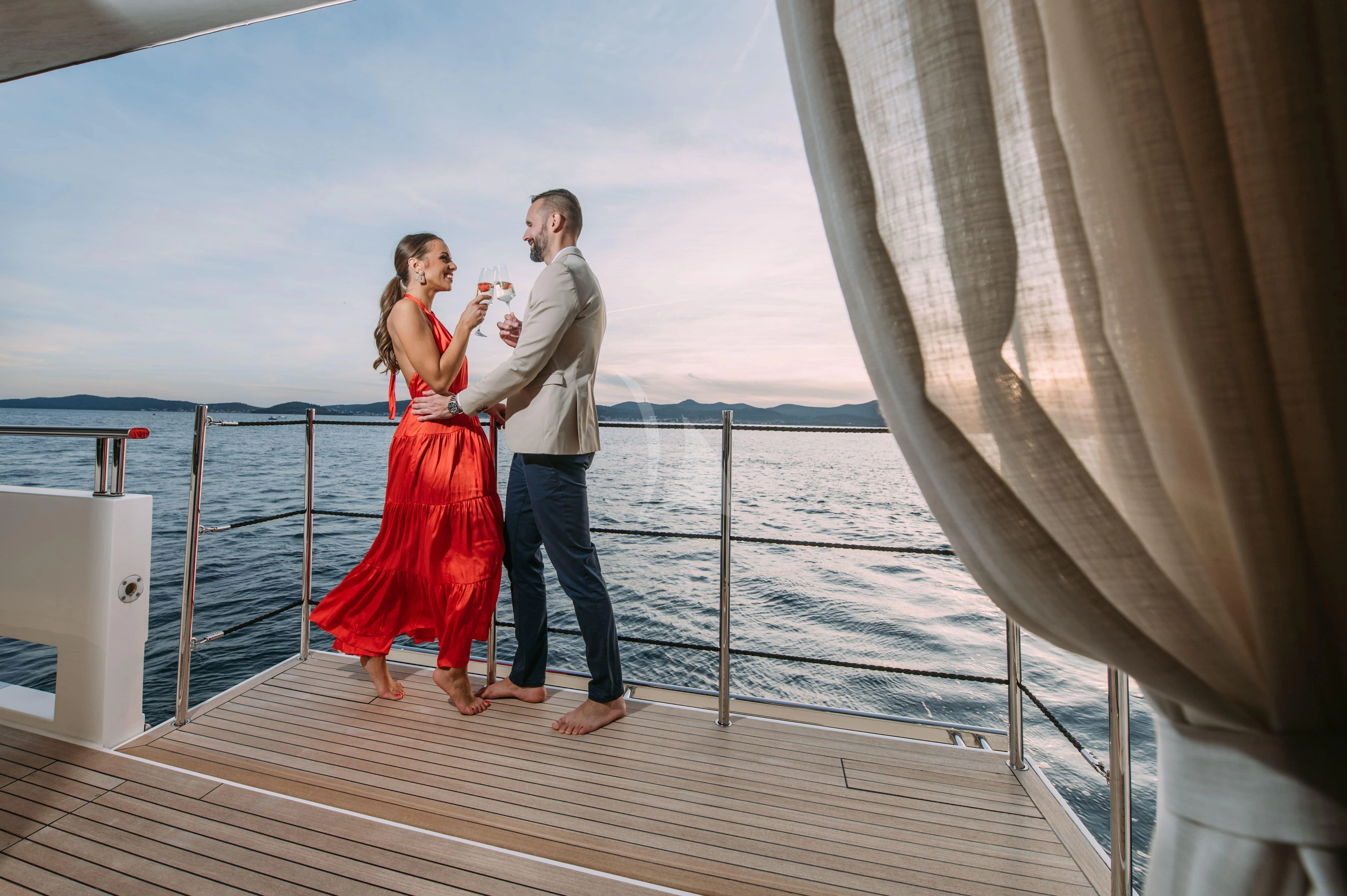 a man and woman posing on a dock aboard PARALOS Yacht for Charter