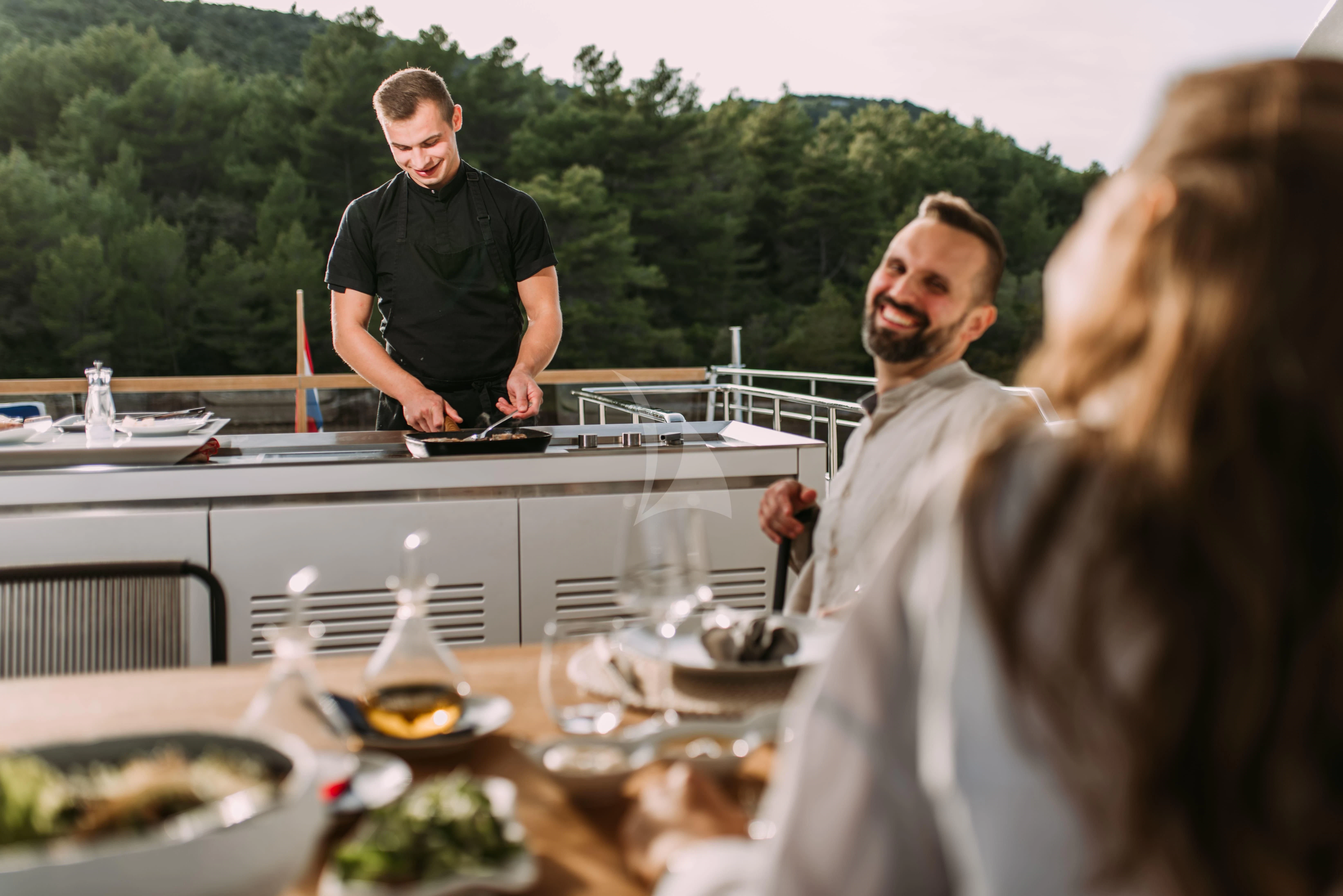 a group of people standing around a table with food on it aboard PARALOS Yacht for Charter
