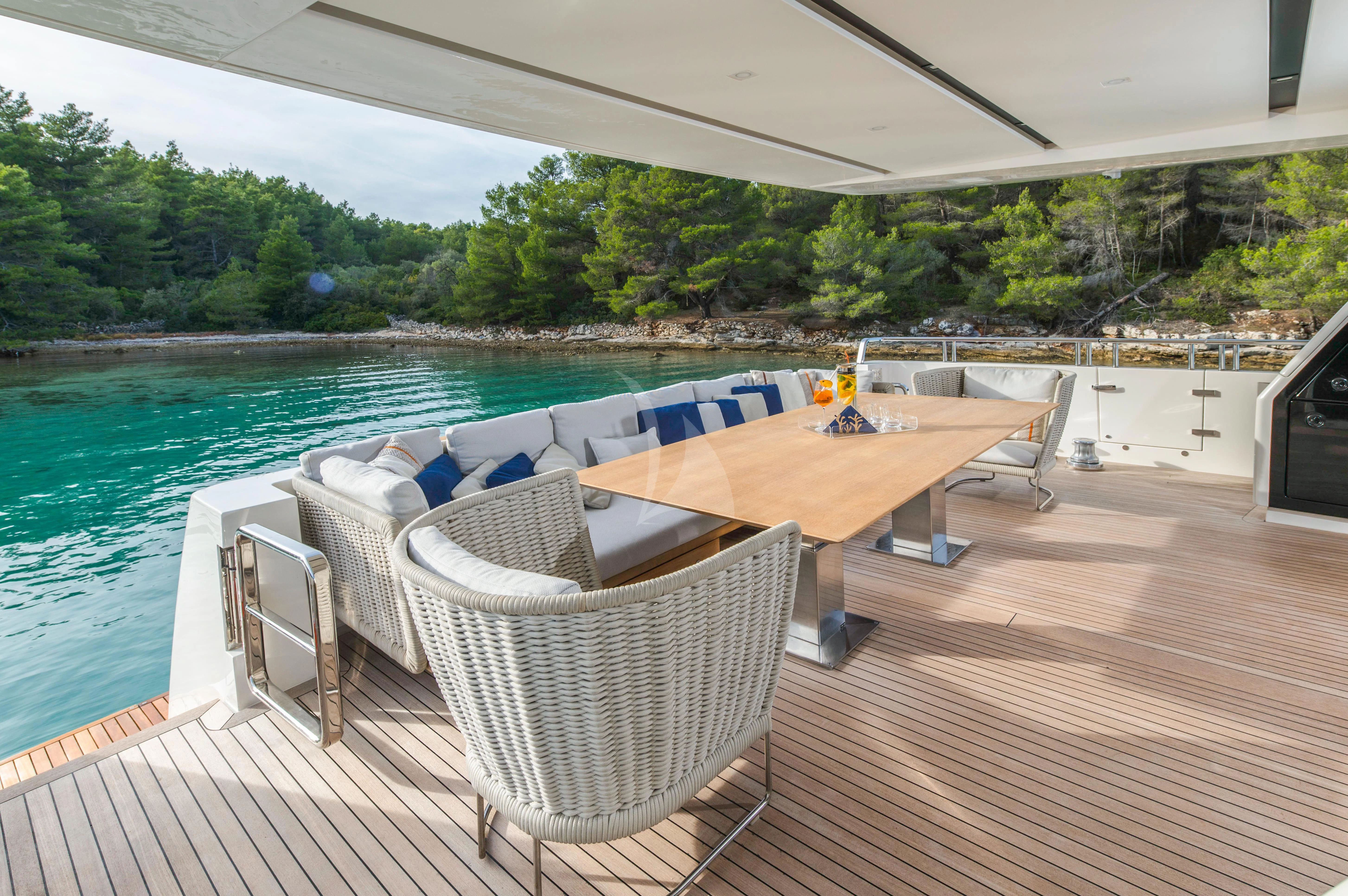 a deck with chairs and a table on it aboard PARALOS Yacht for Charter