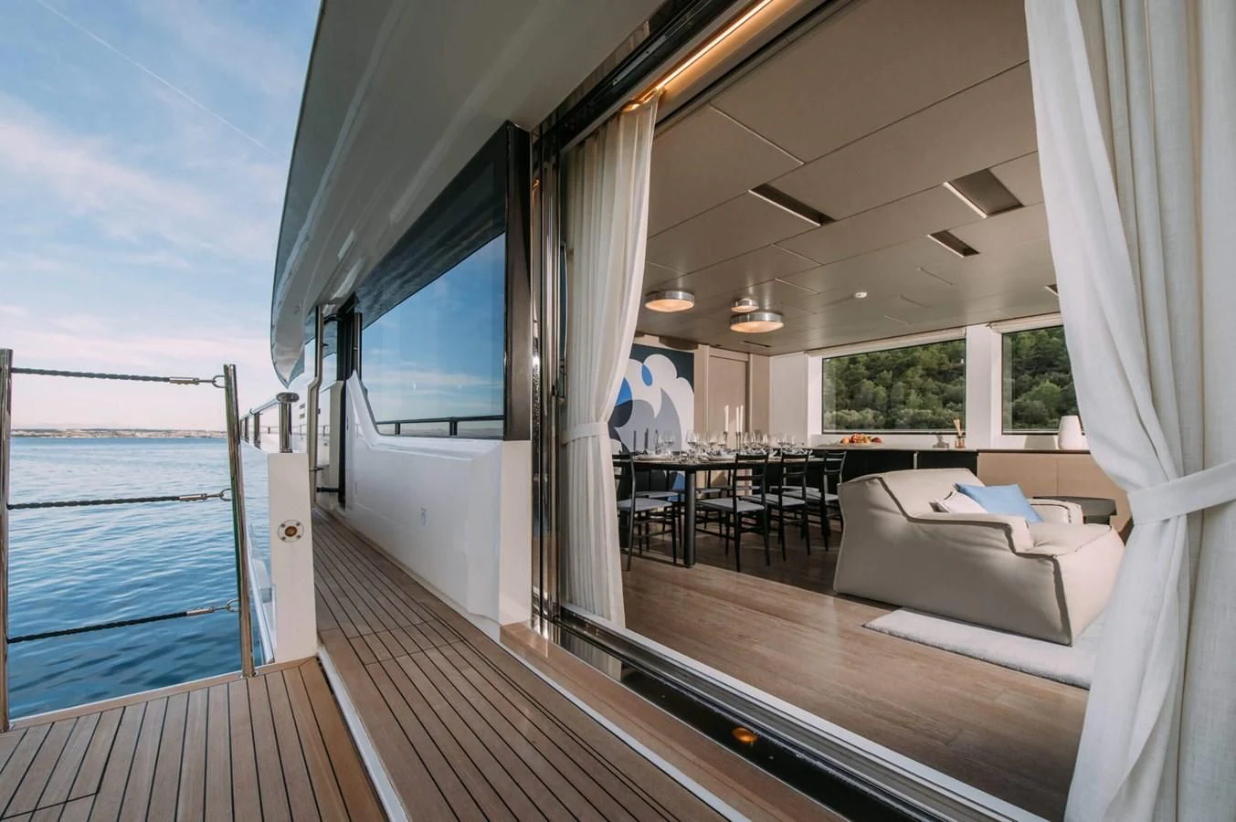 a room with a wood floor and a large window with a view of the ocean aboard PARALOS Yacht for Charter
