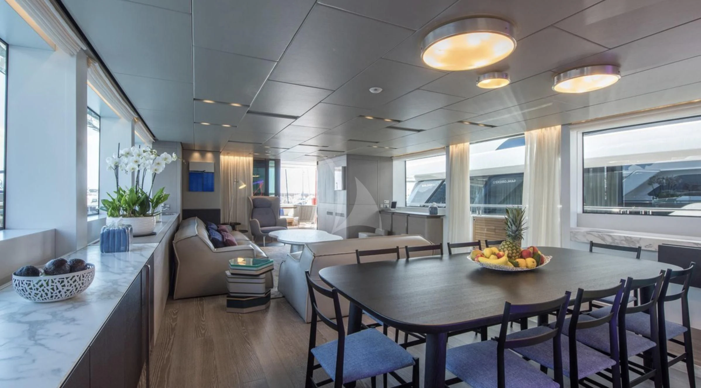 a large room with a table and chairs and a couch aboard PARALOS Yacht for Charter