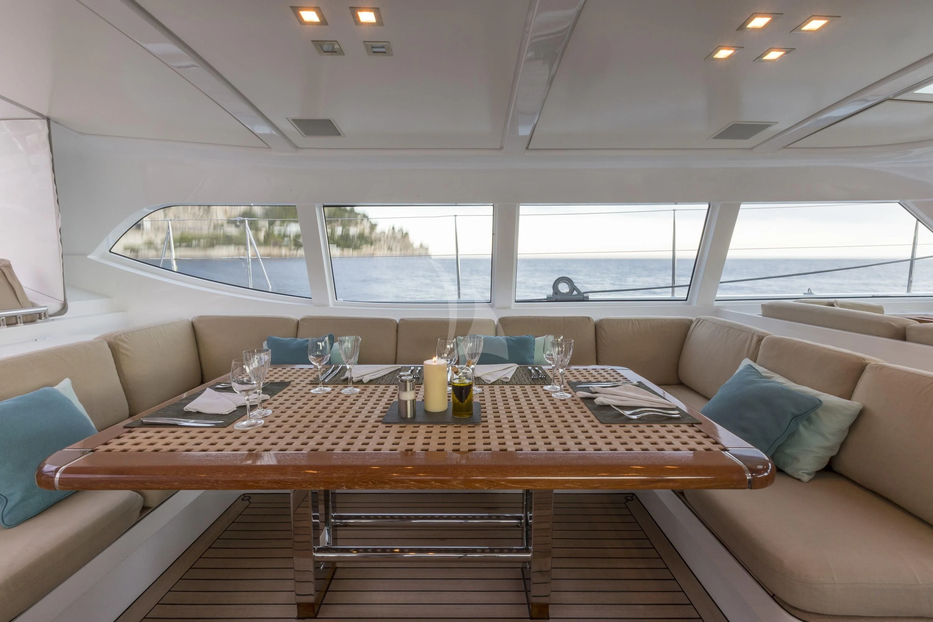a table with a glass and a couch in a room with a window aboard GLISS Yacht for Sale